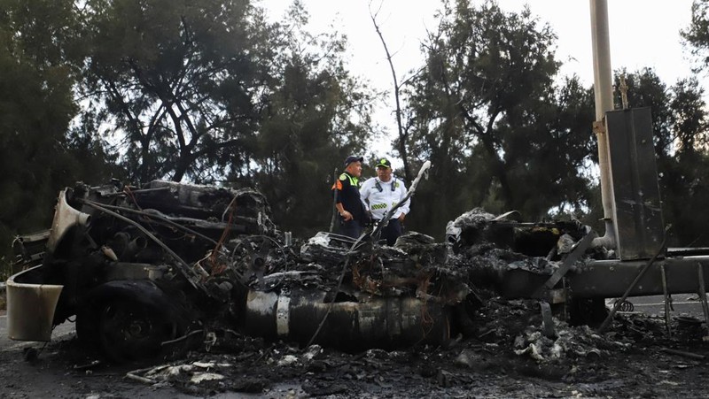 Seorang pria berjalan di samping sisa-sisa hangus sebuah trailer, salah satu kendaraan yang rusak dalam ledakan truk tangki gas di Jalan Ignacio Zaragoza, tempat beberapa orang mengalami luka bakar setelah truk tangki terbalik, di Mexico City, Meksiko, 10 September 2025. (REUTERS/Quetzalli Blanco)