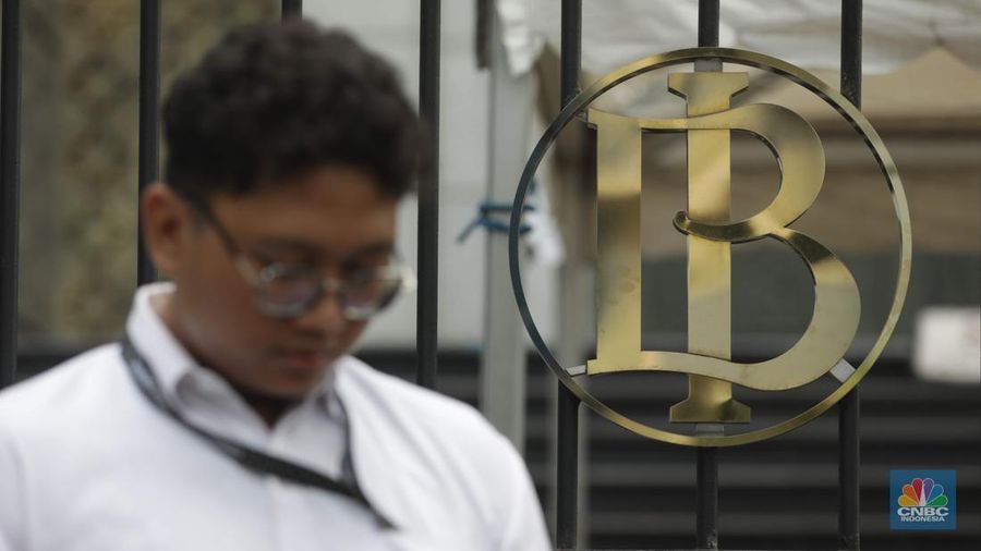Seorang Karyawan berdiri di depan logo Bank Indonesia (BI) di Jakarta, Kamis (11/9/2025).