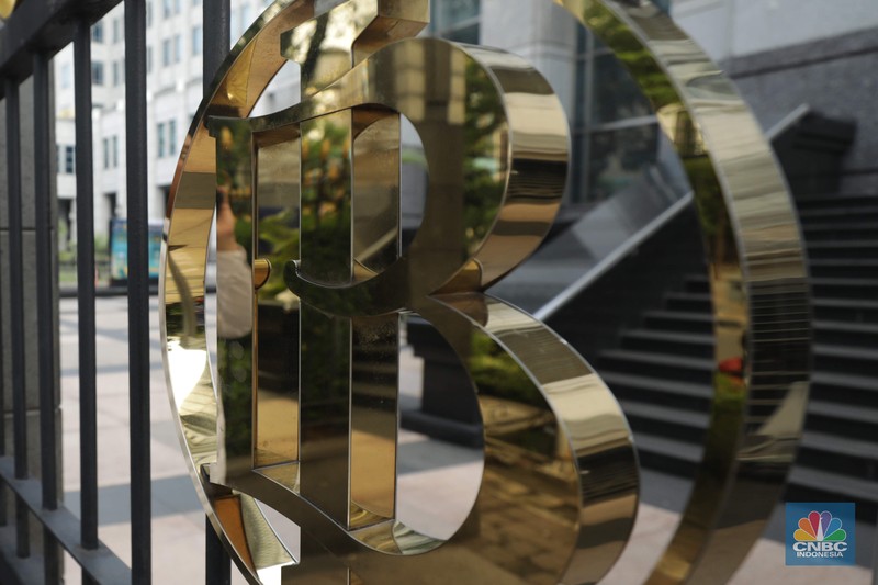 Seorang Karyawan berdiri di depan logo Bank Indonesia (BI) di Jakarta, Kamis (11/9/2025). (CNBC Indonesia/Muhammad Sabki)