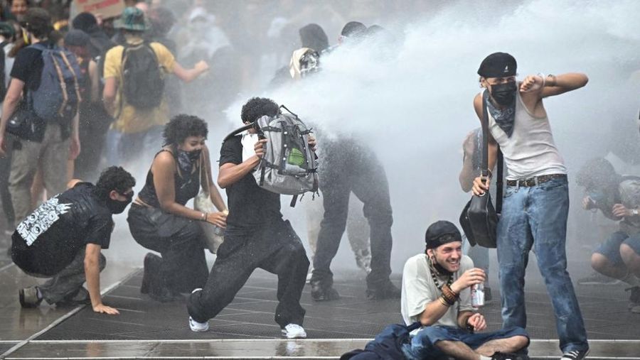 Orang-orang berdemonstrasi di bundaran untuk memblokir lalu lintas sementara petugas polisi berjaga di Pres d'Arenes di Montpellier, sebagai bagian dari gerakan protes akar rumput yang disebut 
