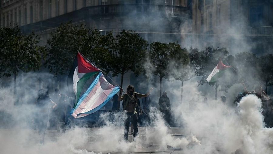 Orang-orang berdemonstrasi di bundaran untuk memblokir lalu lintas sementara petugas polisi berjaga di Pres d'Arenes di Montpellier, sebagai bagian dari gerakan protes akar rumput yang disebut 