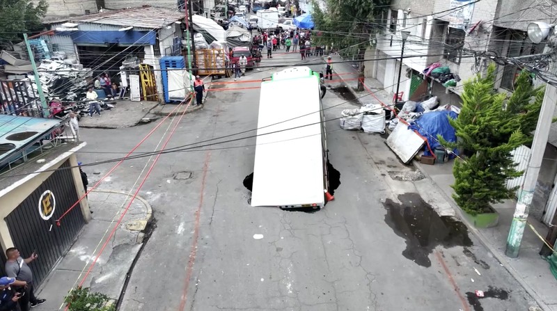 Sebuah truk pengiriman minuman bersoda bermerek Jarritos terperosok ke dalam lubang Sinkhole di wilayah Iztapalapa, Mexico City, pada Sabtu (13/9/2025). (Tangkapan Layar Video Reuters/IZTAPALAPA MAYOR'S OFFICE)