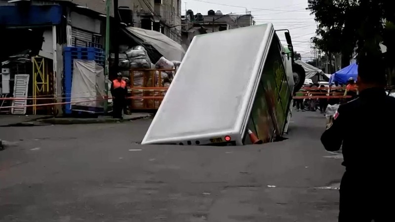Sebuah truk pengiriman minuman bersoda bermerek Jarritos terperosok ke dalam lubang Sinkhole di wilayah Iztapalapa, Mexico City, pada Sabtu (13/9/2025). (Tangkapan Layar Video Reuters/IZTAPALAPA MAYOR'S OFFICE)