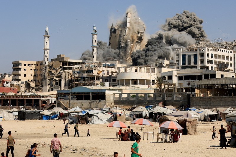 Asap mengepul dari menara hunian Al-Ghefari yang dievakuasi, setelah terkena serangan udara Israel, di Kota Gaza, 15 September 2025. (REUTERS/Dawoud Abu Alkas)