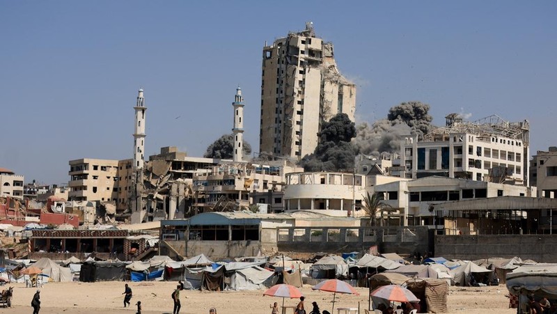 Asap mengepul dari menara hunian Al-Ghefari yang dievakuasi, setelah terkena serangan udara Israel, di Kota Gaza, 15 September 2025. (REUTERS/Dawoud Abu Alkas)