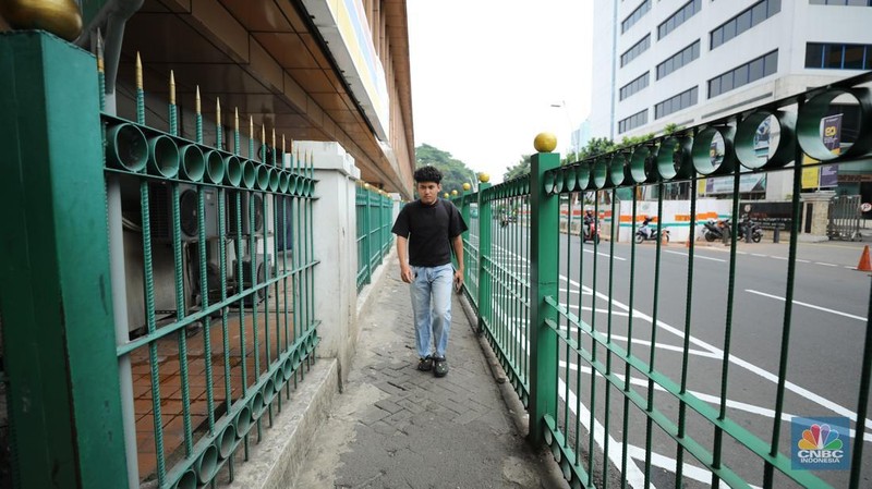Pemerintah Provinsi (Pemprov) Jakarta berkolaborasi dengan PT KAI mulai melakukan uji coba pelican crossing di sisi timur Stasiun Cikini, Jakarta Pusat, Selasa (16/9/2025). (CNBC Indonesia/Tri Susilo)