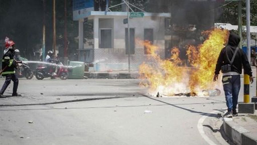 ETIMOR-POLITICS-PROTEST A firefighter extinguishes a blaze set alight by university students protesting the parliaments plan to buy 65 SUVs for lawmakers in Dili, East Timor, on September 16, 2025. East Timor police fired tear gas on September 16 at protesters railing for the second day against a plan to buy new official cars for lawmakers, which became the latest flashpoint in one of the poorest nations in Southeast Asia. (Photo by VALENTINO DARIELL DE SOUSA / AFP)