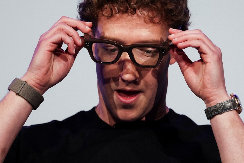Meta CEO Mark Zuckerberg wears the Meta Ray-Ban Display glasses, as he delivers a speech presenting the new line of smart glasses, during the Meta Connect event at the company's headquarters in Menlo Park, California, U.S., September 17, 2025. REUTERS/Carlos Barria