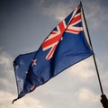 Seorang pria mengibarkan bendera Selandia Baru saat menghadiri acara peringatan untuk korban pembantaian dua masjid di Christchurch pada 24 Maret 2019. (Photo by Anthony WALLACE / AFP/File Foto)