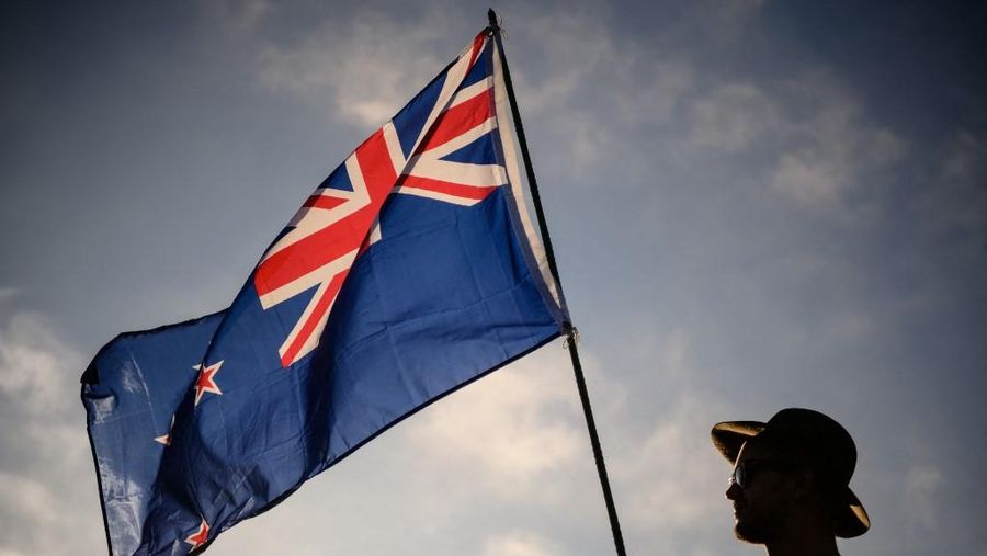 Seorang pria mengibarkan bendera Selandia Baru saat menghadiri acara peringatan untuk korban pembantaian dua masjid di Christchurch pada 24 Maret 2019. (Photo by Anthony WALLACE / AFP/File Foto)