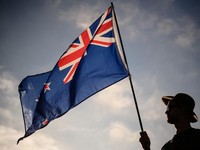 Seorang pria mengibarkan bendera Selandia Baru saat menghadiri acara peringatan untuk korban pembantaian dua masjid di Christchurch pada 24 Maret 2019. (Photo by Anthony WALLACE / AFP/File Foto)