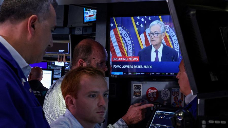 Sejumlah trader melihat layar saat konferensi pers oleh Ketua Federal Reserve AS Jerome Powell setelah pengumuman suku bunga Fed, di lantai Bursa Efek New York (NYSE) di New York City, AS, 17 September 2025. REUTERS/Brendan McDermid