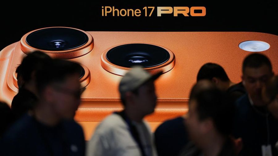 APPLE-CHINA/ Orang-orang berkumpul di depan papan iklan di toko Apple di kawasan Sanlitun, Beijing, saat dimulainya penjualan ponsel pintar seri iPhone 17 baru di Beijing, Tiongkok, 19 September 2025. REUTERS/Maxim Shemetov