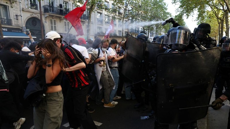 French riot police stand amid tear gas during clashes at a demonstration in Paris as part of a day of nationwide strikes and protests against the government and cuts in the next budget, with supporters of the 