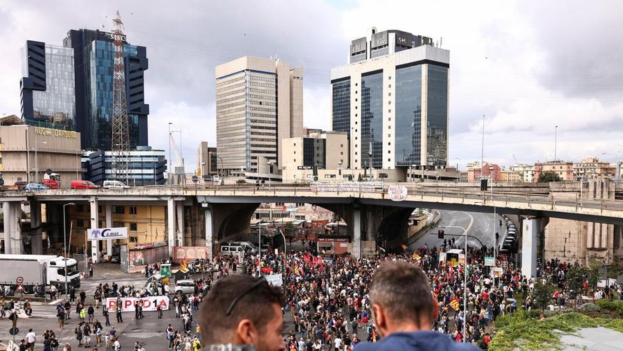 Para demonstran membawa suar asap, sementara para pekerja pelabuhan ikut serta dalam aksi mogok di dekat pelabuhan Genoa sebagai bagian dari protes nasional Para demonstran membawa suar asap, sementara para pekerja pelabuhan ikut serta dalam aksi mogok di dekat pelabuhan Genoa sebagai bagian dari protes nasional