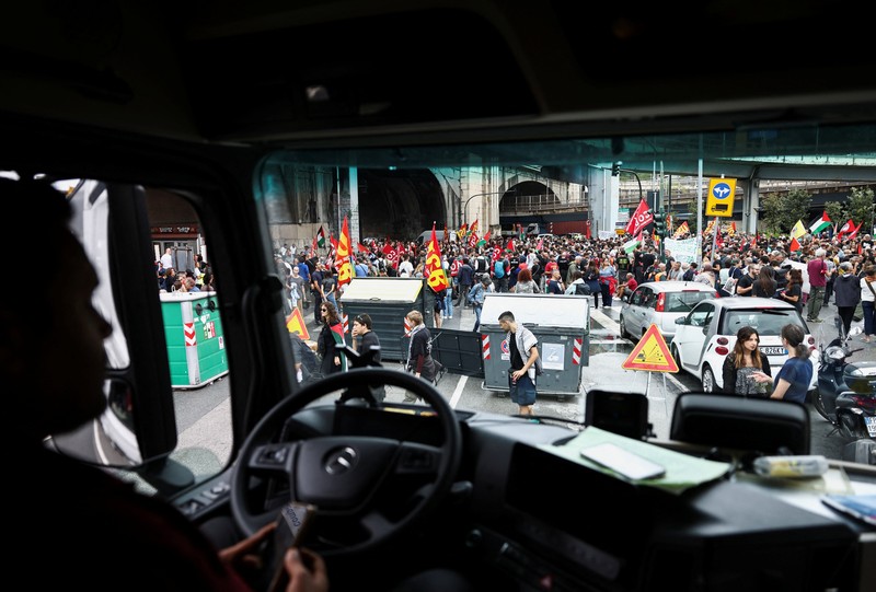 Para demonstran membawa suar asap, sementara para pekerja pelabuhan ikut serta dalam aksi mogok di dekat pelabuhan Genoa sebagai bagian dari protes nasional Para demonstran membawa suar asap, sementara para pekerja pelabuhan ikut serta dalam aksi mogok di dekat pelabuhan Genoa sebagai bagian dari protes nasional