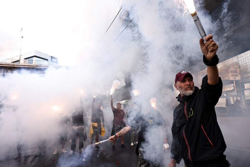 Para demonstran membawa suar asap, sementara para pekerja pelabuhan ikut serta dalam aksi mogok di dekat pelabuhan Genoa sebagai bagian dari protes nasional Para demonstran membawa suar asap, sementara para pekerja pelabuhan ikut serta dalam aksi mogok di dekat pelabuhan Genoa sebagai bagian dari protes nasional