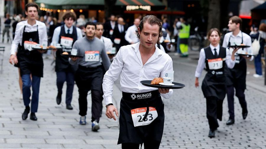Pelayan membawa nampan berisi secangkir kopi, croissant, dan segelas air ikut serta dalam Cafe Race di Paris, Prancis, 21 September 2025. Pelayan membawa nampan berisi secangkir kopi, croissant, dan segelas air ikut serta dalam Cafe Race di Paris, Prancis, 21 September 2025. (REUTERS/Stephanie Lecocq)