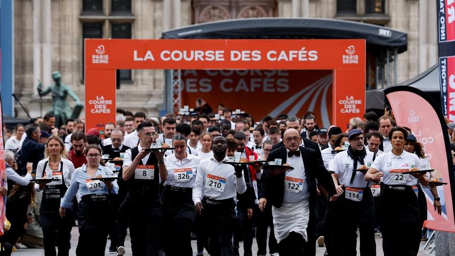 Pelayan membawa nampan berisi secangkir kopi, croissant, dan segelas air ikut serta dalam Cafe Race di Paris, Prancis, 21 September 2025. (REUTERS/Stephanie Lecocq)