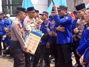 Aksi Polisi Bagikan Air Mineral dan Roti ke Massa Buruh di DPR