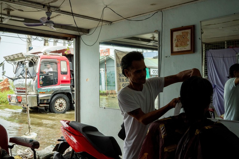 Seorang pria mengarungi jalan yang banjir setelah hujan, yang diperparah oleh Badai Tropis Bualoi, di Dela Paz, Binan, provinsi Laguna, Filipina, 26 September 2025. (REUTERS/Noel Celis)