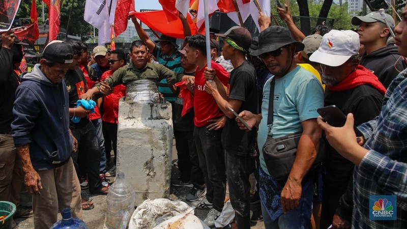 Aksi memperingati Hari Tani Nasional (HTN) ke-65 di Jalan Medan Merdeka Selatan, Jakarta Pusat, Rabu (24/9/2025), diwarnai aksi ekstrem berupa cor badan. (CNBC Indonesia/Faisal Rahman)