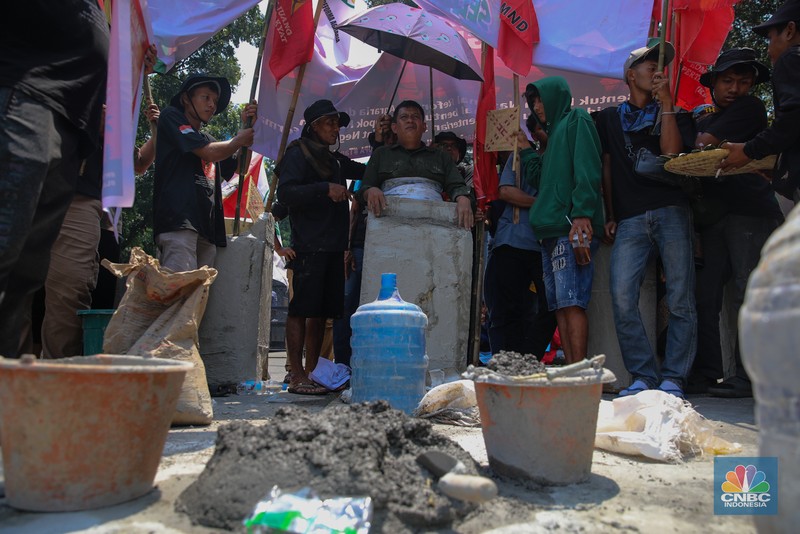 Aksi memperingati Hari Tani Nasional (HTN) ke-65 di Jalan Medan Merdeka Selatan, Jakarta Pusat, Rabu (24/9/2025), diwarnai aksi ekstrem berupa cor badan. (CNBC Indonesia/Faisal Rahman)