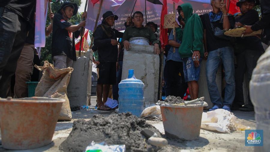 Aksi memperingati Hari Tani Nasional (HTN) ke-65 di Jalan Medan Merdeka Selatan, Jakarta Pusat, Rabu (24/9/2025), diwarnai aksi ekstrem berupa cor badan. Aksi memperingati Hari Tani Nasional (HTN) ke-65 di Jalan Medan Merdeka Selatan, Jakarta Pusat, Rabu (24/9/2025), diwarnai aksi ekstrem berupa cor badan. (CNBC Indonesia/Faisal Rahman)