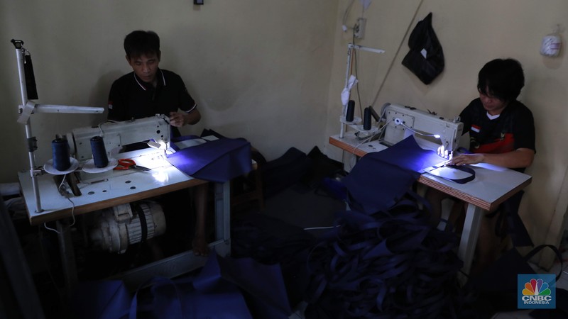 Pekerja menjahit tas di konveksi sablon rumahan sedjati, Jati Padang, Jakarta, Rabu (24/9/2025). (Srealm Indonesia/Muhammad Sabki)