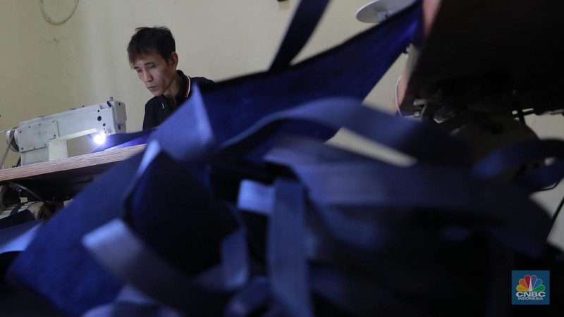 Pekerja menjahit tas di konveksi sablon rumahan sedjati, Jati Padang, Jakarta, Rabu (24/9/2025). (CNBC Indonesia/Muhammad Sabki)