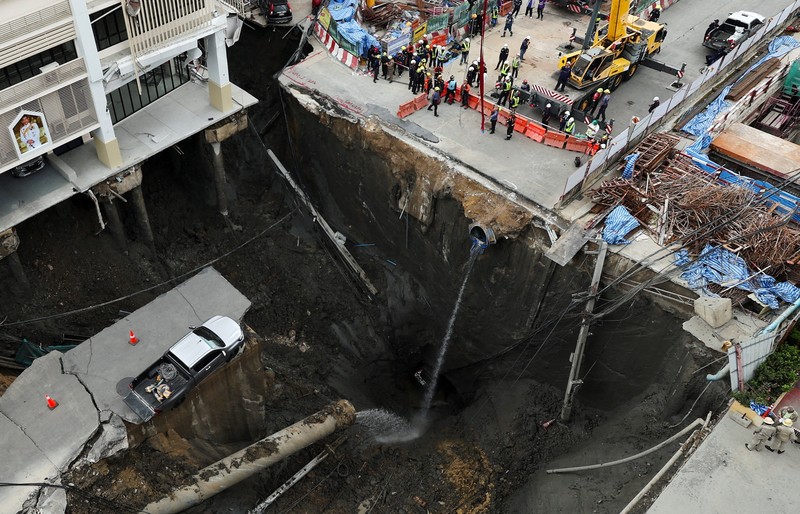 Sebuah kendaraan terhuyung-huyung di tepi lubang runtuhan besar yang terbuka di Jalan Samsen dekat Rumah Sakit Vajira, di Bangkok, Thailand, 24 September 2025. (REUTERS/Chalinee Thirasupa)