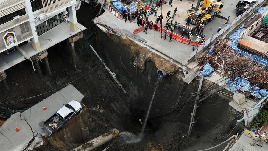 Sebuah kendaraan terhuyung-huyung di tepi lubang runtuhan besar yang terbuka di Jalan Samsen dekat Rumah Sakit Vajira, di Bangkok, Thailand, 24 September 2025. (REUTERS/Chalinee Thirasupa)