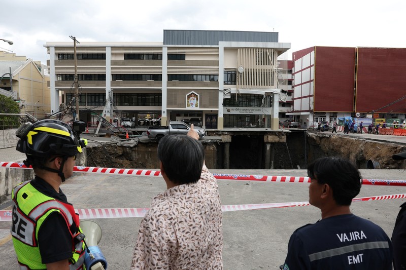 Sebuah kendaraan terhuyung-huyung di tepi lubang runtuhan besar yang terbuka di Jalan Samsen dekat Rumah Sakit Vajira, di Bangkok, Thailand, 24 September 2025. (REUTERS/Chalinee Thirasupa)