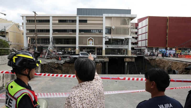 Sebuah kendaraan terhuyung-huyung di tepi lubang runtuhan besar yang terbuka di Jalan Samsen dekat Rumah Sakit Vajira, di Bangkok, Thailand, 24 September 2025. (REUTERS/Chalinee Thirasupa)