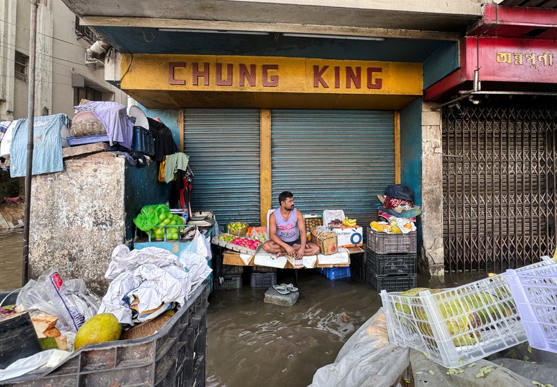 Orang-orang berjalan melalui jalan yang tergenang air setelah hujan deras di Kolkata, India, 24 September 2025. Orang-orang berjalan melalui jalan yang tergenang air setelah hujan deras di Kolkata, India, 24 September 2025. (REUTERS/Sahiba Chawdhary)