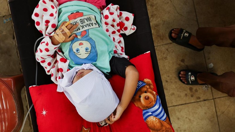 Muhammad Setiawan Pratama, 11, seorang siswa sekolah dasar menerima perawatan keracunan makanan setelah makan makanan sekolah gratis yang disponsori pemerintah, di sebuah klinik darurat di dalam aula kabupaten di Bandung, provinsi Jawa Barat, Indonesia, 25 September 2025. (REUTERS/Willy Kurniawan)