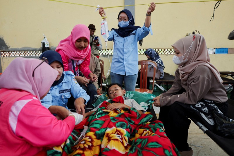 Muhammad Setiawan Pratama, 11, seorang siswa sekolah dasar menerima perawatan keracunan makanan setelah makan makanan sekolah gratis yang disponsori pemerintah, di sebuah klinik darurat di dalam aula kabupaten di Bandung, provinsi Jawa Barat, Indonesia, 25 September 2025. (REUTERS/Willy Kurniawan)