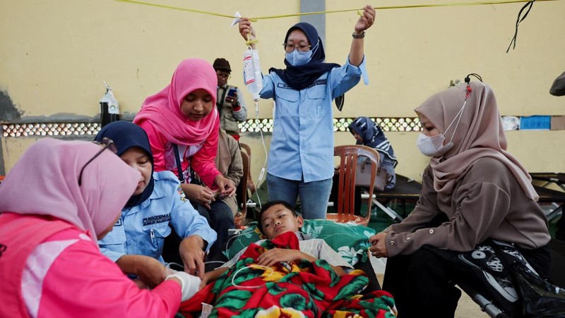 Muhammad Setiawan Pratama, 11, seorang siswa sekolah dasar menerima perawatan keracunan makanan setelah makan makanan sekolah gratis yang disponsori pemerintah, di sebuah klinik darurat di dalam aula kabupaten di Bandung, provinsi Jawa Barat, Indonesia, 25 September 2025. (REUTERS/Willy Kurniawan)