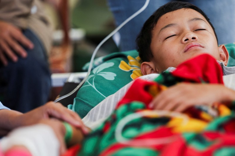 Muhammad Setiawan Pratama, 11, seorang siswa sekolah dasar menerima perawatan keracunan makanan setelah makan makanan sekolah gratis yang disponsori pemerintah, di sebuah klinik darurat di dalam aula kabupaten di Bandung, provinsi Jawa Barat, Indonesia, 25 September 2025. (REUTERS/Willy Kurniawan)