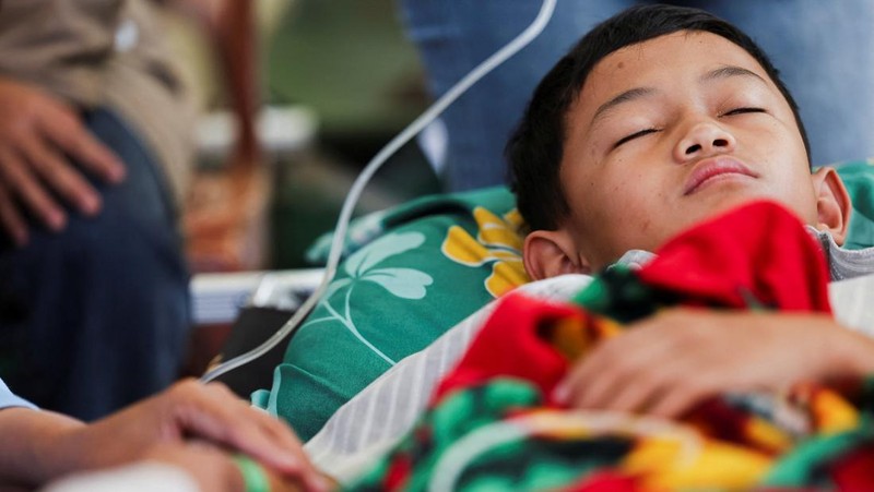 Muhammad Setiawan Pratama, 11, seorang siswa sekolah dasar menerima perawatan keracunan makanan setelah makan makanan sekolah gratis yang disponsori pemerintah, di sebuah klinik darurat di dalam aula kabupaten di Bandung, provinsi Jawa Barat, Indonesia, 25 September 2025. (REUTERS/Willy Kurniawan)