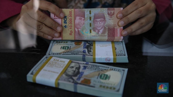 Petugas menjunjukkan mata uang Dolar Amerika Serikat (AS) dan Rupiah di VIP Money Changer, Jakarta, Kamis (25/9/2025). (CNBC Indonesia/Faisal Rahman)