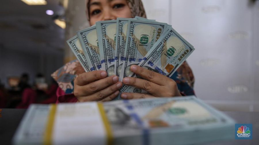 Petugas menjunjukkan mata uang Dolar Amerika Serikat (AS) di VIP Money Changer, Jakarta, Kamis (25/9/2025). (CNBC Indonesia/Faisal Rahman)