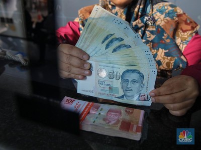 Petugas menjunjukkan mata uang Dolar Singapura dan Rupiah di VIP Money Changer, Jakarta, Kamis (25/9/2025). (CNBC Indonesia/Faisal Rahman)