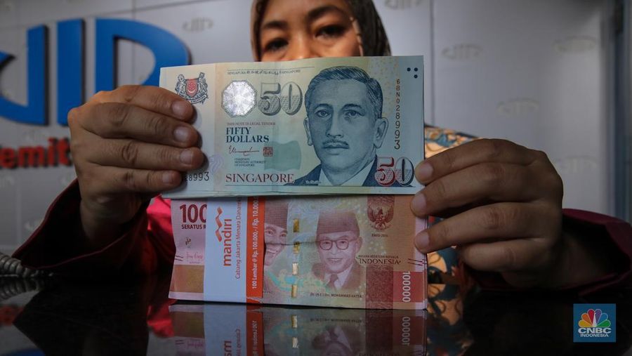 Petugas menjunjukkan mata uang Dolar Singapura di VIP Money Changer, Jakarta, Kamis (25/9/2025). Petugas menjunjukkan mata uang Dolar Singapura di VIP Money Changer, Jakarta, Kamis (25/9/2025). (CNBC Indonesia/Faisal Rahman)