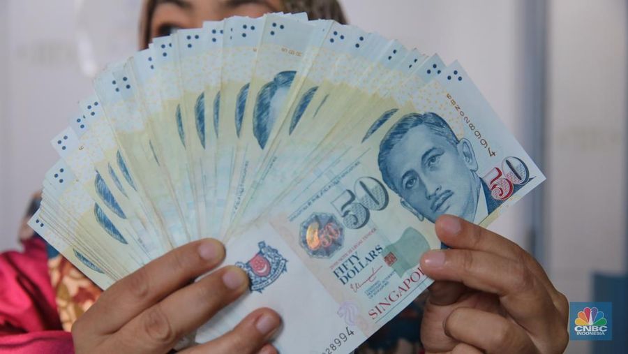 Petugas menjunjukkan mata uang Dolar Singapura di VIP Money Changer, Jakarta, Kamis (25/9/2025). Petugas menjunjukkan mata uang Dolar Singapura di VIP Money Changer, Jakarta, Kamis (25/9/2025). (CNBC Indonesia/Faisal Rahman)
