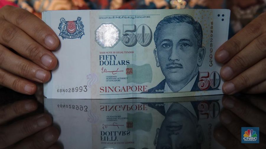 Petugas menjunjukkan mata uang Dolar Singapura di VIP Money Changer, Jakarta, Kamis (25/9/2025). (CNBC Indonesia/Faisal Rahman)
