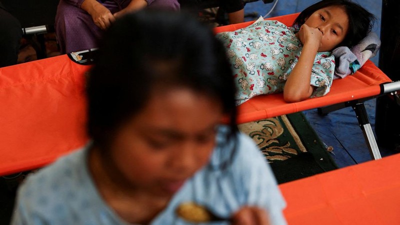 Muhammad Setiawan Pratama, 11, seorang siswa sekolah dasar menerima perawatan keracunan makanan setelah makan makanan sekolah gratis yang disponsori pemerintah, di sebuah klinik darurat di dalam aula kabupaten di Bandung, provinsi Jawa Barat, Indonesia, 25 September 2025. (REUTERS/Willy Kurniawan)