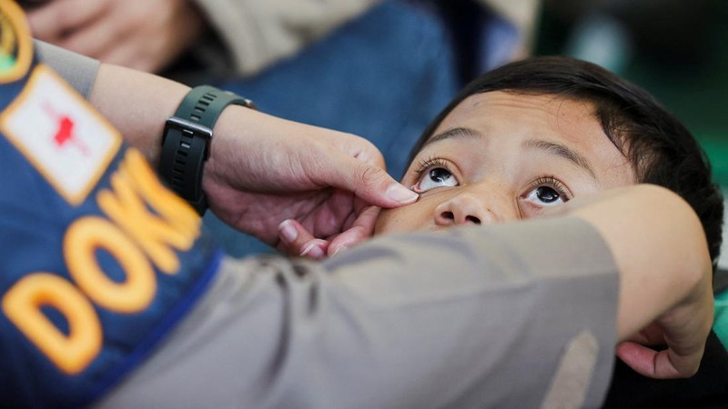 Muhammad Setiawan Pratama, 11, seorang siswa sekolah dasar menerima perawatan keracunan makanan setelah makan makanan sekolah gratis yang disponsori pemerintah, di sebuah klinik darurat di dalam aula kabupaten di Bandung, provinsi Jawa Barat, Indonesia, 25 September 2025. (REUTERS/Willy Kurniawan)