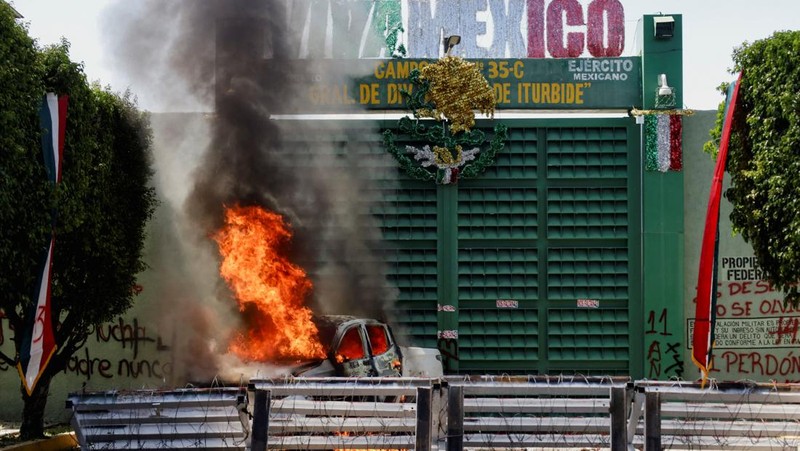 Sebuah kendaraan yang dibakar oleh mahasiswa dari Sekolah Guru Pedesaan Raul Isidro Burgos di Ayotzinapa terbakar selama protes di luar batalyon infanteri ke-27, sebagai bagian dari demonstrasi menjelang peringatan 11 tahun hilangnya 43 mahasiswa, di Iguala, Meksiko, 23 September 2025. (REUTERS/Oscar Guerrero)