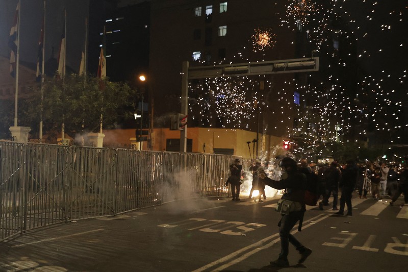 PERU-PROTEST/ A Molotov cocktail falls on a police officer during a demonstration organised by a youth collective called